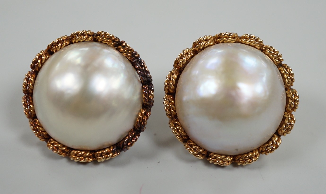 A pair of modern continental yellow metal and mabe pearl set ear clips, diameter 22mm, gross weight 18.2 grams.